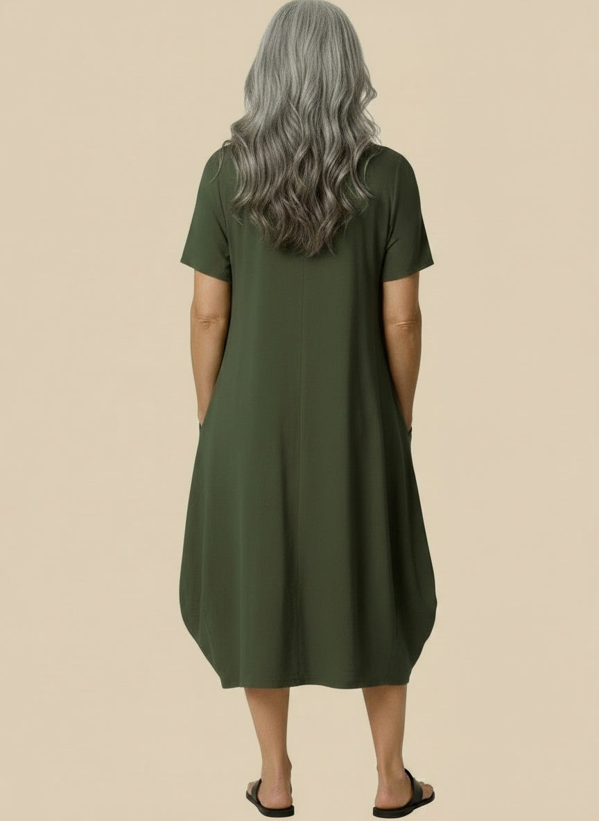 Back pose of the model wearing Midi zomerjurk met ronde hals en zakken voor dames – ruim en luchtig