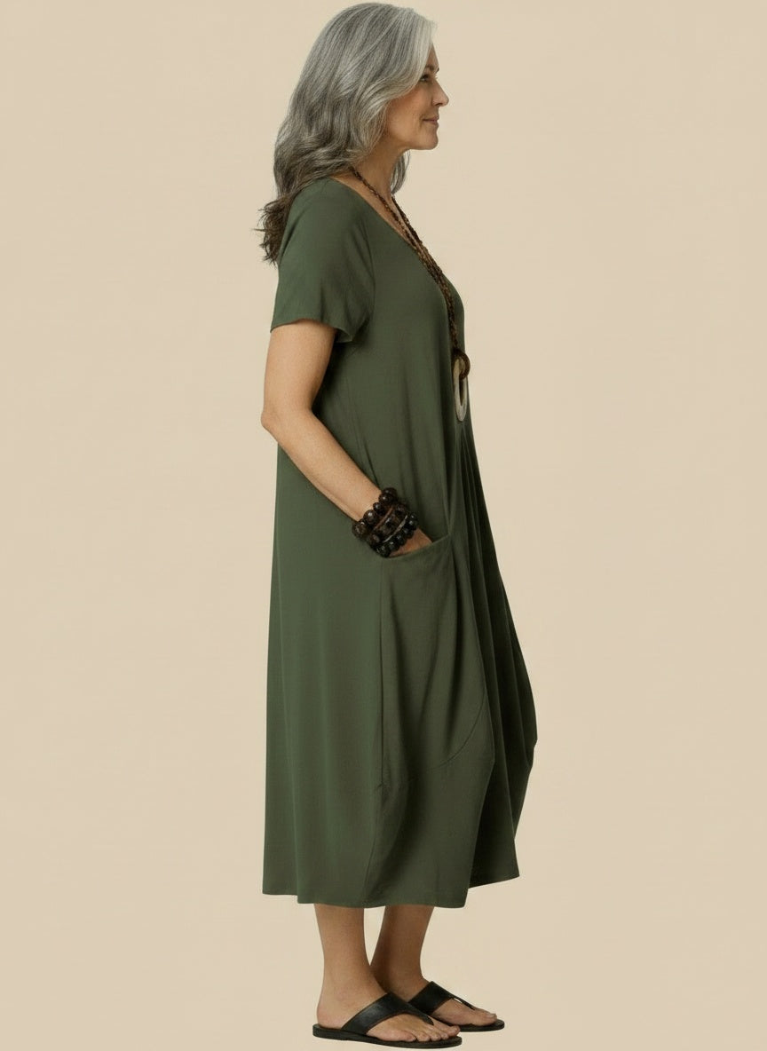Side profile of the model wearing Midi zomerjurk met ronde hals en zakken voor dames – ruim en luchtig