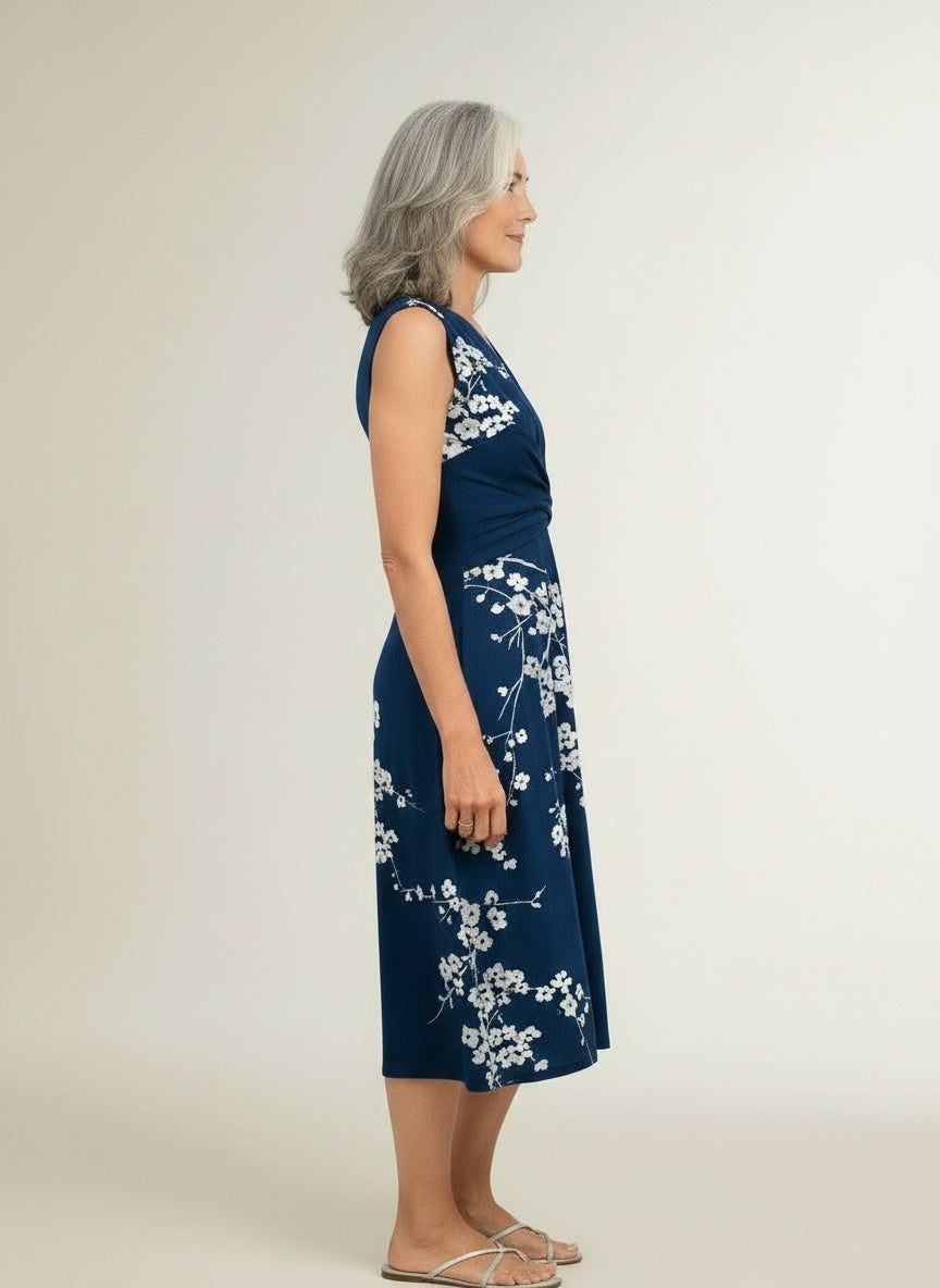Side profile of the model wearing Mouwloze zomerjurk met overslag voor dames – vrouwelijk en verfijnd